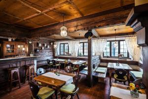 a restaurant with wooden walls and tables and chairs at Das Halali - dein kleines Hotel an der Zugspitze in Ehrwald
