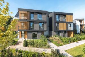 an apartment building with a garden in front of it at Comfort Apartments Botanika in Gdańsk