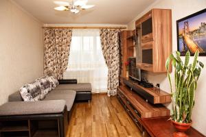 a living room with a couch and a tv at KemHotel Квартирное Бюро in Kemerovo