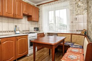 a kitchen with wooden cabinets and a wooden table at KemHotel Квартирное Бюро in Kemerovo