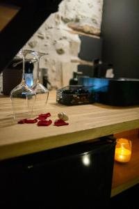 un comptoir en bois avec des verres et des pédales de rose rouge dans l'établissement LOVE Suites & SPA "Le Chai" avec lit rond, à Médis