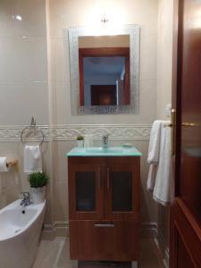 薩達的住宿－PISO ACOGEDOR EN SADA COZY FLAT IN SADA WiFi，一间带水槽和镜子的浴室