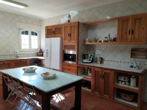 a kitchen with a table and a white refrigerator at FINCA EL PIRUETANO in Toledo