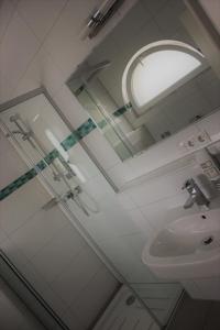 a bathroom with a mirror and a sink at Hotel Germersheimer Hof in Germersheim