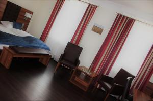 a bedroom with a bed and a desk and chairs at Hotel Germersheimer Hof in Germersheim