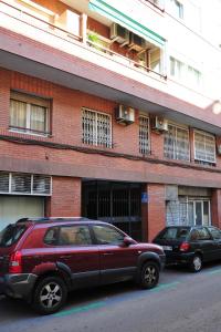 dos coches estacionados frente a un edificio de ladrillo en Hostal Bejar en Barcelona