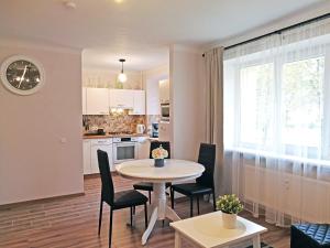 a kitchen and living room with a table and chairs at Šiauliai Central Spot Apartment - Draugystes pr. in Šiauliai