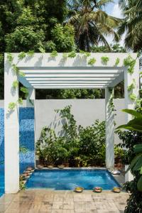マドゥライにあるJC Residency Maduraiの植物が植えられたパビリオンのある青いプール