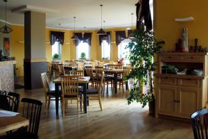 a dining room with tables and chairs and windows at Penzion v Zálesí in Mladá Boleslav