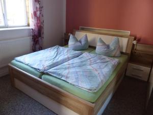 ein Bett mit weißer Bettwäsche und Kissen in einem Schlafzimmer in der Unterkunft Ferienwohnung Seidel in Bad Schandau