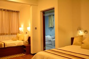 a hotel room with two beds and a bathroom at Gloria Grand Hotel in Unawatuna +37 photos