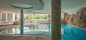 a swimming pool in a hotel lobby with a pool at Wellness & Beauty Hotel Alte Post in Sankt Anton am Arlberg
