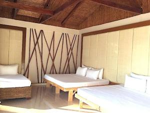 a room with two beds and a wooden ceiling at Kaiyana Boracay Beach Resort in Boracay