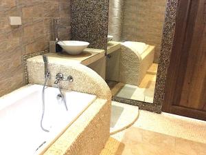 a bathroom with a tub and a sink and a mirror at Kaiyana Boracay Beach Resort in Boracay