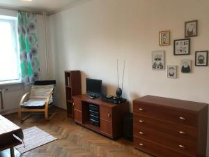 un soggiorno con cassettiera e TV sopra di Mal's Apartment a Łódź