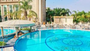 a large blue swimming pool in front of a building at Al Masa Hotel Nasr City in Cairo