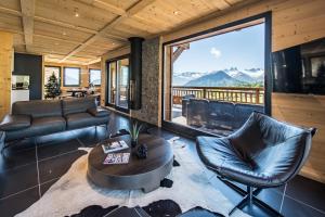 Una sala de estar con una mesa y sillas y una gran ventana. en Harfang des Neiges, en La Toussuire