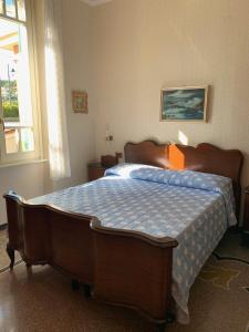 a bedroom with a bed with a blue comforter at Resort Villa Rosa Maria in Savona