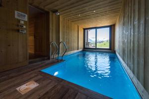 una piscina en una casa de madera con ventana en Harfang des Neiges, en La Toussuire