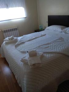 a bedroom with two white beds with towels on them at Lujo en el Centro in Castellón de la Plana