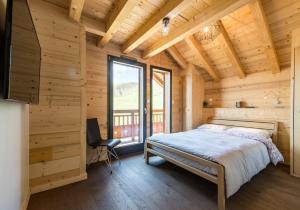Un dormitorio con una cama y una ventana grande. en Harfang des Neiges, en La Toussuire 11 fotos más