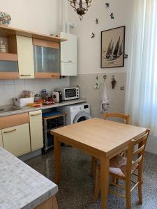 a kitchen with a wooden table and a kitchen with a stove at Resort Villa Rosa Maria in Savona