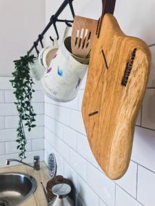 a wooden cutting board hanging on a kitchen wall at Home garden oasis in Timişoara