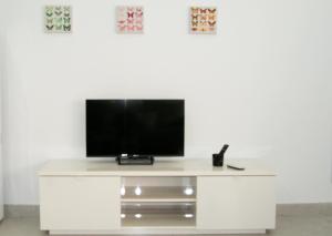 un centro di intrattenimento bianco con TV a schermo piatto in cima di Apartamento El Andén de la Estación a Málaga