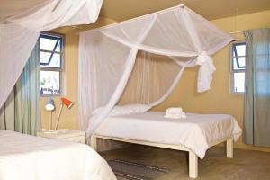 Tempat tidur dalam kamar di Sesfontein Guesthouse