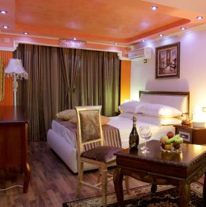 Hotel Villa Fernando Tirana في تيرانا: غرفة نوم بسرير وطاولة مع كرسي