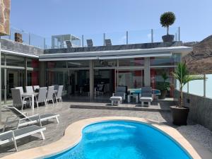 een huis met een zwembad naast een patio bij Suecia Villa Opal Anfi Tauro in Mogán
