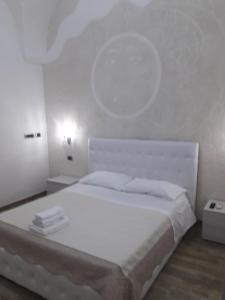 een witte slaapkamer met een groot bed met witte lakens bij SOLE E LUNA in Taranto