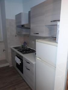 een witte keuken met een fornuis en een koelkast bij SOLE E LUNA in Taranto