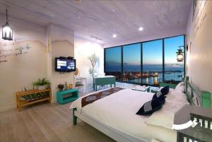 a bedroom with a large bed and a large window at 85 Cape Inn in Kaohsiung