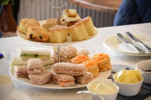 une assiette de sandwichs et de pâtisseries sur une table dans l'établissement Countryside Escape - The Night Owl, à Alnwick