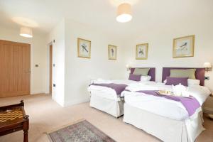 a bedroom with two beds and a table at Countryside Escape - The Night Owl in Alnwick