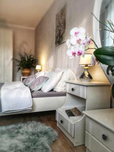 a bedroom with a bed with white sheets and flowers at Home garden oasis in Timişoara