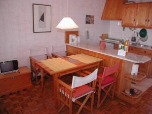 cocina con mesa de madera, sillas y encimera en Apartment Wolf en Lourinhã