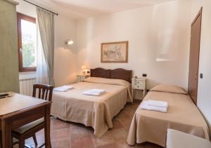 two beds in a room with a table and two chairs at Bed & Breakfast Al Pian d'Assisi in Assisi