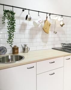 a kitchen with white cabinets and a sink at Home garden oasis in Timişoara +6 photos