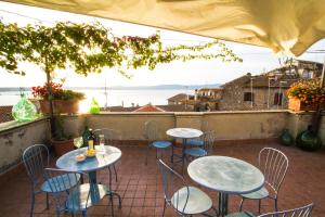 a patio with tables and chairs and a view of the ocean at La Dimora di Checchino in Anguillara Sabazia
