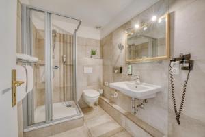 een badkamer met een douche, een toilet en een wastafel bij Hotel Strandschlösschen in Travemünde