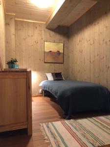 a bedroom with a bed and a wooden wall at Laukvik Suites in Laukvik