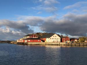 a group of buildings next to a body of water at Laukvik Suites in Laukvik