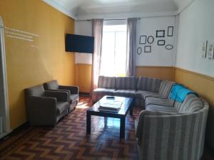 uma sala de estar com sofás e uma mesa de centro em Old Évora Hostel em Évora