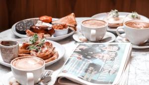 a table topped with cups of coffee and plates of food at Le Monde Hotel in Edinburgh
