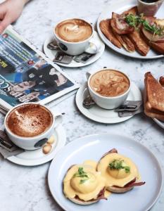 a table with plates of food and cups of coffee at Le Monde Hotel in Edinburgh