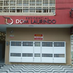 un bâtiment avec une porte de garage blanche et un panneau rouge dans l'établissement Residencial Dom Laurindo, à Paulo Afonso