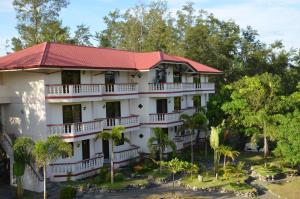 a large white building with a red roof at Seasun Beach Resort & Hotel in Santa Cruz