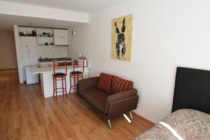 a living room with a chair and a kitchen at Roca 771 Apartment in Buenos Aires